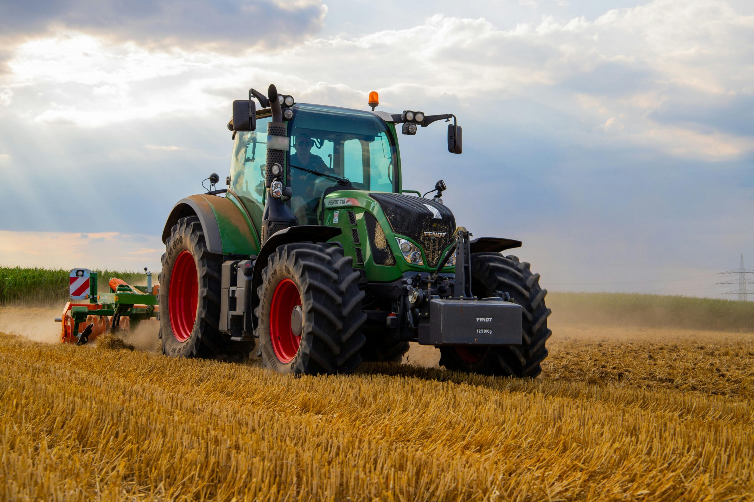 green tractor plowing