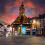 A beautifully lit historic clock tower in Newbury, England, at sunset with dramatic skies.